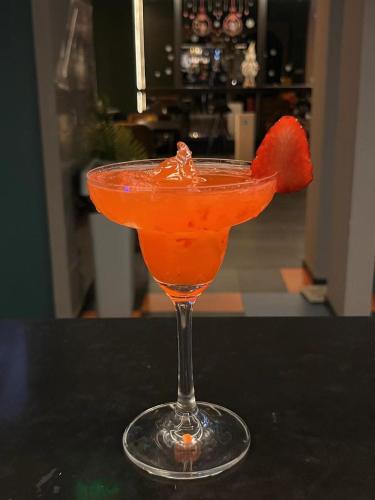 an orange drink in a glass with a strawberry in it at Dayin Youth Hostel - East Nanjing Road & People's Square & The Bund -Large Social Area -Bar -Café -Gym -Free Laundry Luggage Storage -24H Front Desk -English Service in Shanghai
