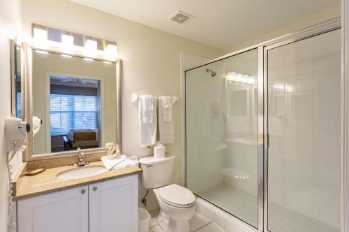y baño con ducha, aseo y lavamanos. en Positano Vacation Rental, en Lely Resort