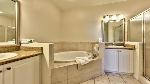 a bathroom with a tub and a sink and a mirror at Genoa Vacation Rental in Naples