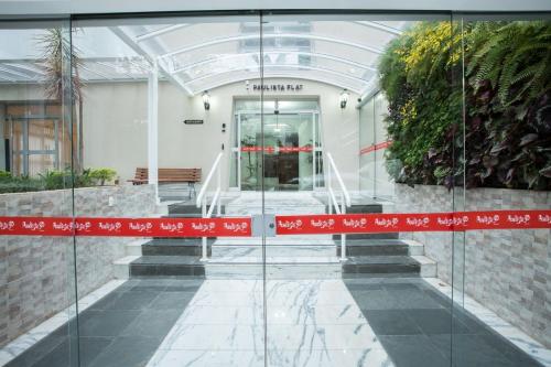 a glass entrance to a building with a red ribbon at Paulista Flat in São Paulo