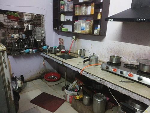 uma pequena cozinha com um lavatório e um fogão em Baba Boys Hostel and Baba Trailer Truck Transport em Lucknow