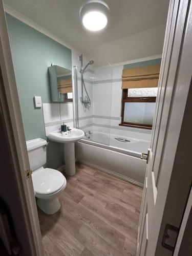 a bathroom with a toilet and a sink at Woodside Lodge, Weybourne, Holt in Weybourne