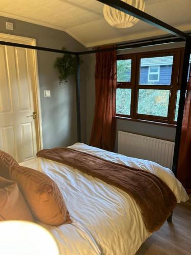 a bedroom with a large bed in a room at Woodside Lodge, Weybourne, Holt in Weybourne