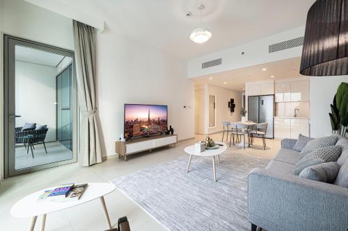 - un salon avec un canapé et une télévision dans l'établissement SmartStay at Downtown Views - Best Burj Khalifa View - Brand New Luxury Apartments, à Dubaï