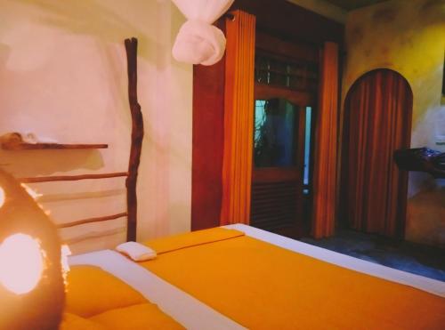 a bedroom with an orange bed and a door at SD3M ART GALLERY Villa in Dickwella