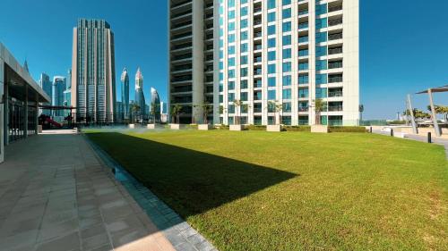 a large field of grass in front of a tall building at SmartStay at Downtown Views - Best Burj Khalifa View - Brand New Luxury Apartments in Dubai