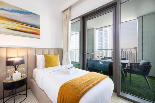a bedroom with a bed and a balcony with a tub at SmartStay at Downtown Views - Best Burj Khalifa View - Brand New Luxury Apartments in Dubai