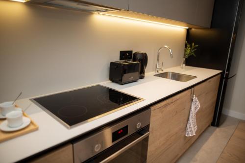 a small kitchen with a sink and a microwave at Belgrade Simfonia - One bedroom apartment in Belgrade