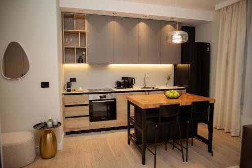a kitchen with a wooden table and a counter top at Belgrade Simfonia - One bedroom apartment in Belgrade