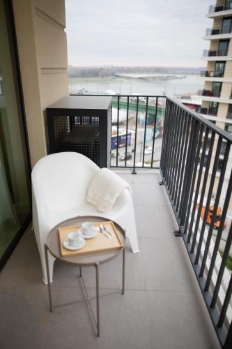 a balcony with a white couch and a table at Belgrade Simfonia - One bedroom apartment in Belgrade