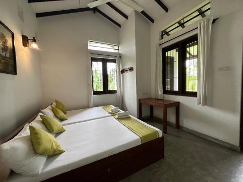 ein großes Bett in einem Zimmer mit zwei Fenstern in der Unterkunft Rockydale Home Stay in Kandy