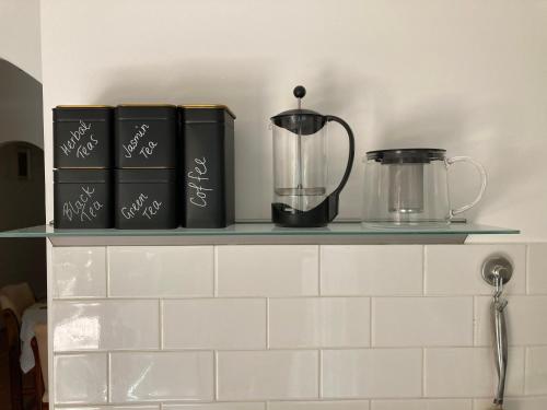 a shelf with books and a blender on it at Carolyn's Cottage in Adelaide