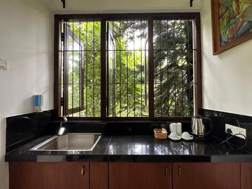 a kitchen with a sink and a large window at Rockydale Home Stay in Kandy