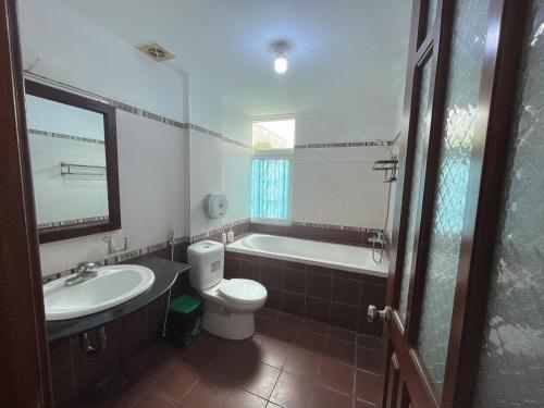 a bathroom with a tub and a toilet and a sink at Hotel Nam Sơn in Dực Liễn