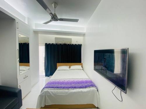 a bedroom with a bed and a ceiling fan at Cozy Studio Apartment Basundhara in Dhaka