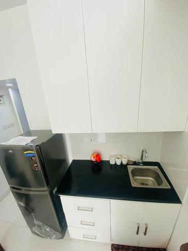 a small kitchen with a sink and a refrigerator at Cozy Studio Apartment Basundhara in Dhaka