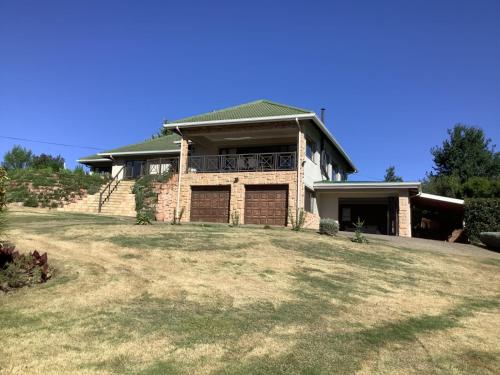 a large brick house with a large yard at The Bells in the berg flat in Underberg