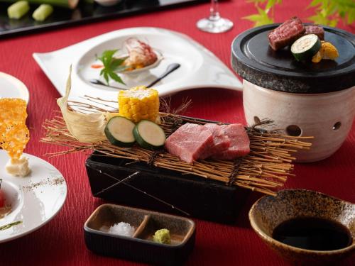 een tafel met eten op een rode tafel bij TennenOnsen Hinatanoyado Nichinan Miyazaki - Vacation STAY 18743v in Nichinan