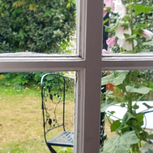 d'une fenêtre avec vue sur le jardin. dans l'établissement Le vieux pré de la motte, à Villers-sur-Mer