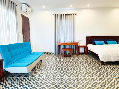 a hotel room with a bed and a couch at Eco Inn in Phumĭ Réach Born