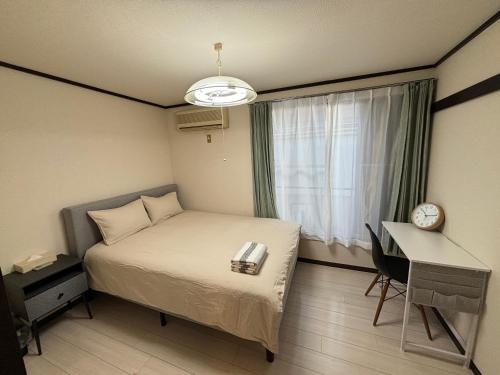 1 dormitorio con cama, escritorio y ventana en 新宿区韩国美食街紧邻韩国广场房源05, en Tokio