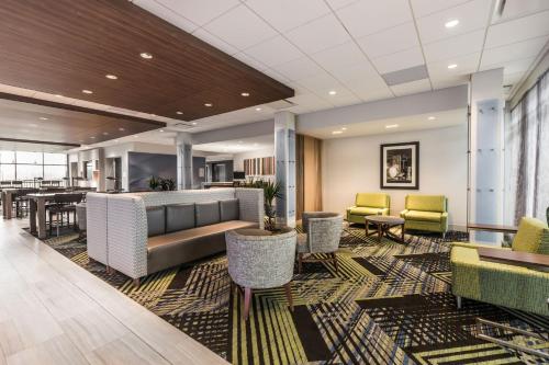 a lobby with chairs and a couch and tables at Holiday Inn Express & Suites - Welland in Welland