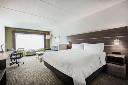 a hotel room with a large bed and a desk at Holiday Inn Express & Suites - Welland in Welland