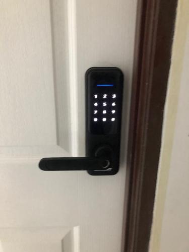 a door opener with a cell phone on a door at SKYN SMART HOME in Ipoh
