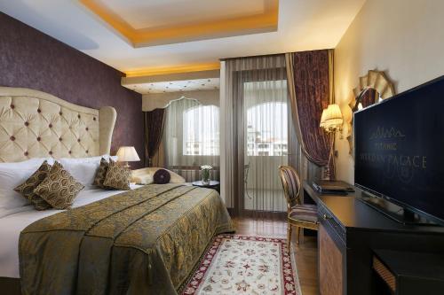 a hotel room with a bed and a flat screen tv at Titanic Mardan Palace in Lara