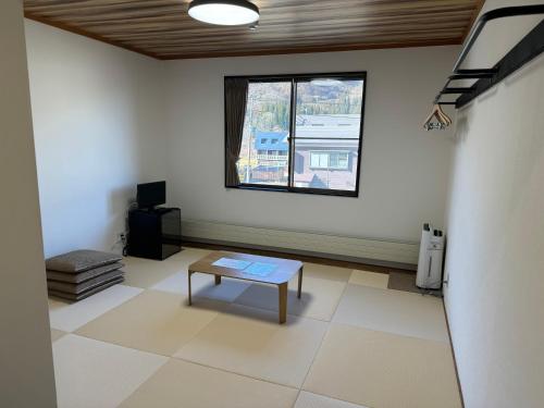 an empty room with a table and a window at K・Lodge in Yuzawa