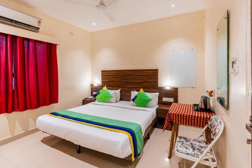 a bedroom with a bed and a table and a red window at Treebo Express Inn in Mumbai