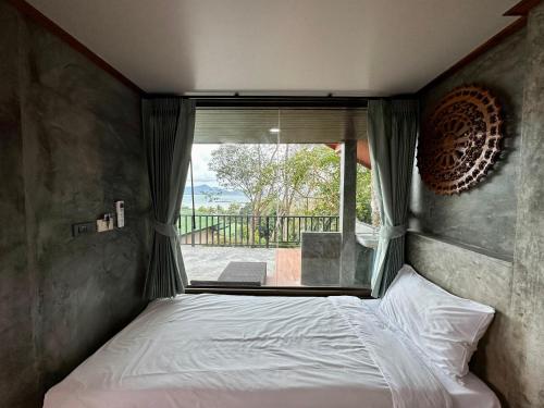 a bedroom with a bed in front of a window at Rinna Resort in Ko Mook