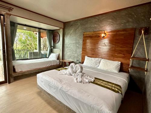 ein Schlafzimmer mit zwei Betten, auf denen Handtücher liegen in der Unterkunft Rinna Resort in Ko Mook