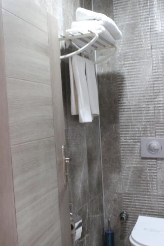a bathroom with a shower with a toilet and towels at ANGRAND HOTEL in Ankara