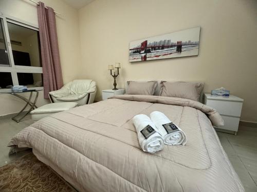 a bedroom with a large bed with two towels at Your Dubai delight in Dubai