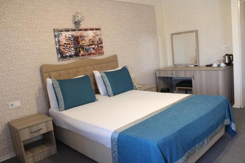 um quarto com uma cama grande e almofadas azuis em ANGRAND HOTEL em Ancara