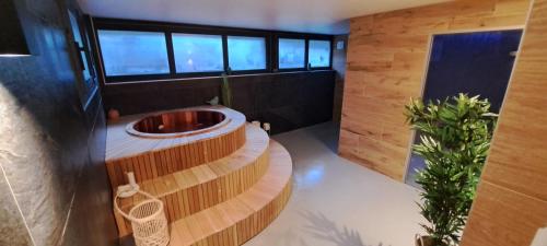 a bathroom with a tub in the middle of a room at Alti'Pic Hôtel in Le Mont-Dore