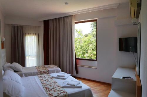 a hotel room with two beds and a window at Uğur Otel in Kas