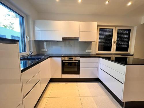 a kitchen with white cabinets and black counter tops at Viel Platz in Burghausen für Freunde und Familie in Burghausen