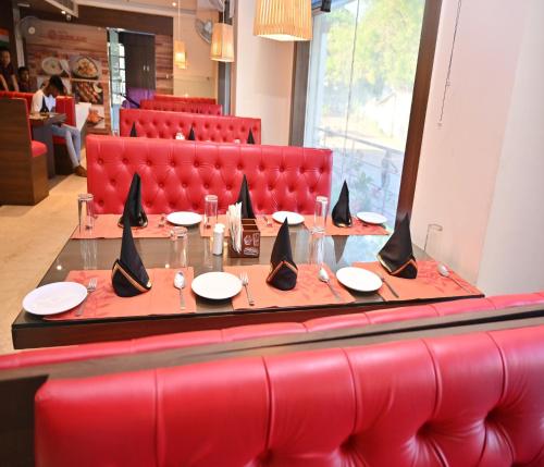 a long table in a restaurant with plates and napkins at Hotel Silver Land New Digha with Rooftop Pool in Digha