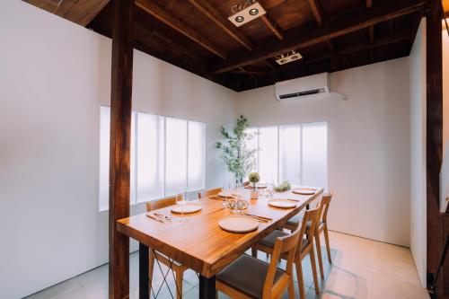 uma sala de jantar com uma mesa de madeira e cadeiras em One Harajuku: Private Oasis em Tóquio