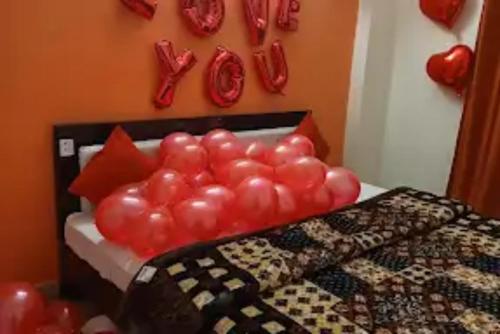 um quarto com uma cama com balões vermelhos na parede em Hotel Sunshine Cave , Ghaziabad em Ghaziabad