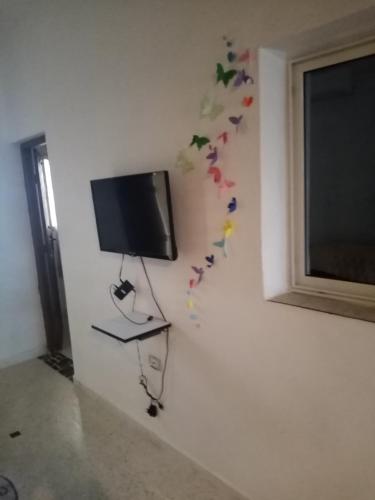 a flat screen tv on a wall with butterflies on it at Appartement Daly in Raoued