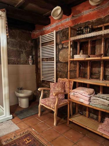a bathroom with a toilet and a chair in a room at Casa Roma in Población de Abajo