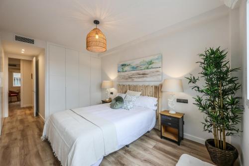 a bedroom with a white bed and a potted plant at Luxury Plaza De Castilla in Madrid