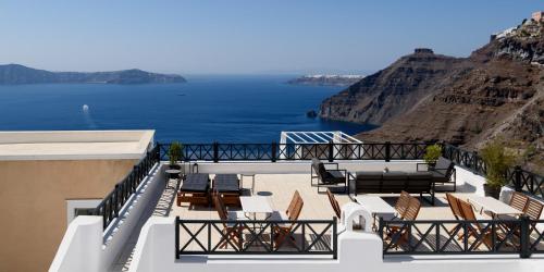 Un balcón con sillas y vistas al océano. en Firalia, Casa in Rock Suites en Fira
