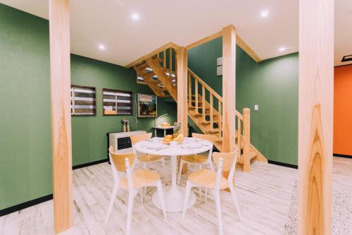 a dining room with green walls and a table and chairs at Yuzawa Onsen Lodge 1min to LIFT A House in Seki