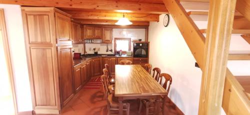 a kitchen with a wooden table and chairs at Maison Sarteur Alloggio ad uso turistico -VDA-LA THUILE- 0065 in La Thuile