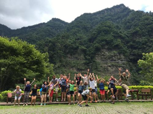 a group of people posing for a picture in front of a mountain at Raisinay in Nanzhuang