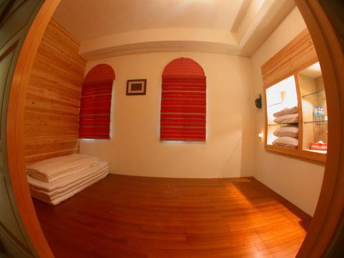 a room with a sauna with red windows and wooden floors at Raisinay in Nanzhuang